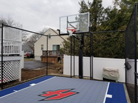 Small, partially fenced Braintree, MA basketball court with custom H logo.
