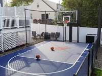 Two basketballs posing on blue and grey basketball court in Braintree, MA, after finishing landscape and hardscape touches around it were completed.