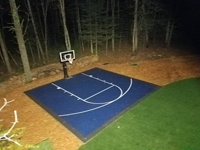 Backyard basketball court as part of a larger project including stump removal, landscaping, firepit, lighting, and a putting green in Hanover, MA.