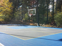 Backyard basketball court in Hanover, MA. Whatever your sport, you could have a court surface and accessories of your own.