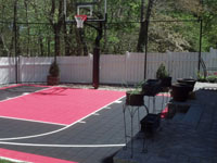Work on this black and red court in a small space in Hingham, MA started even before winter had ended.
