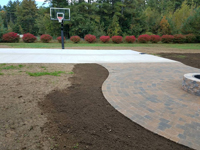 Detail work around a basketball court featuring Celtics logo, with fire pit, patio, and light for night play, in Londonderry, NH.