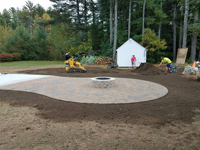 Detail work around basketball court featuring Celtics logo, with fire pit, patio, and light for night play, in Londonderry, NH.