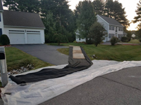 A look at steps taken to avoid landscape damage during construction of basketball court featuring Celtics logo, with fire pit, patio, and light for night play, in Londonderry, NH.