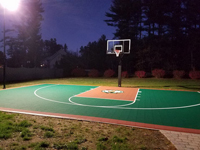 Basketball court featuring Celtics logo, with fire pit, patio, and light for night play, in Londonderry, NH.