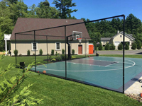Beautiful green and black basketball court in finished landscape setting in Marion, MA.