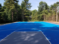 Large royal blue and titanium basketball court with golf seahorse logo at Bay Club in Mattapoisett, MA, as viewed from beneath hoop at one end, looking at the opposite end, showing the sheer size..