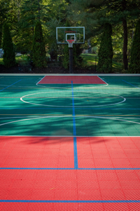 Backyard basketball court with net for tennis or volleyball, fresh sod, in-ground trampoline in Pembroke, MA.