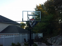 Backyard basketball court hoop adjustment in Stoneham, MA.