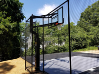 Highlight on hoop and rebound fence with black and grey home basketball court in Wellesley, MA.