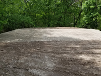 Packed sand and gravel is ready for concrete foundation of black and grey home backyard basketball court in Wellesley, MA.