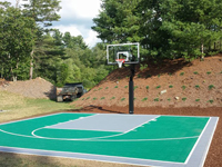 Small green backyard basketball court in Bridgewater, MA.