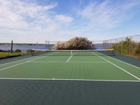 Resurfaced tennis court in shades of green, by the water in Bristol, RI.