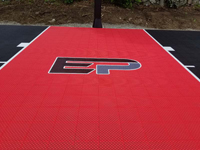 Closeup of red key on black basketball court, showing off black and grey custom EP log in Brockton, MA.