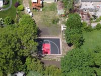 Drone view of black and red backyard basketball court oasis of fun in Dedham, MA.