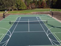 Large tennis and basketball court in shades of green, installed in Easton, MA.