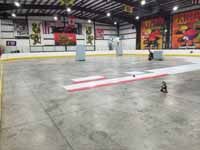 We traveled to Kapolei, Hawaii and inside to resurface two inline skate hockey rinks with Versacourt Speed Indoor tile. This is a look at just over half of the court, with installation begun at the center line, and pallets of material staged beyond.