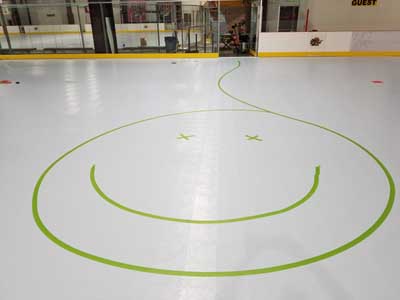 We traveled to Kapolei, Hawaii and inside to resurface two inline skate hockey rinks with Versacourt Speed Indoor tile. This is a happy face picture taped onto the first of those courts.