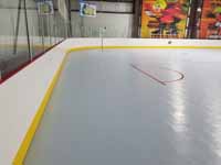 We traveled to Kapolei, Hawaii and inside to resurface two inline skate hockey rinks with Versacourt Speed Indoor tile. This is a view across part of one end of the completed rink, looking at the goal lines.