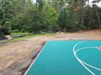 Green and red residential basketball court in Middleborough, MA.