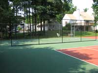 Restoration and resurfacing of large tennis court into multicourt with hopscotch and shuffleboard for a condo complex in Duxbury, Massachusetts. Shuffleboard area separated by containment fence.