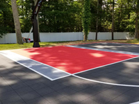 Closeup of red and silver key on charcoal basketball court in Taunton, MA.