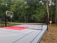 Basketball court in ice blue and red, with removable, adjustable net for tennis and other games, in Topsfield, MA.