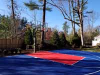 Navy blue and red residential basketball court on asphalt surface in Wellesley, MA.