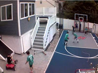 Kids playing on small blue and grey basketball court, with optional hockey net and custom logo, in Braintree, MA.