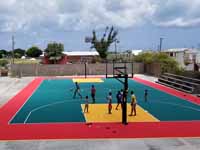 Replacement tennis and basketball courts in Codrington, Barbuda, courtest of Australia, the Red Cross, and community effort, part of the ongoing recovery from hurricane Irma. Shown here, people trying out the new basketball surface and goals.