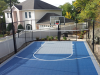 Mixed use basketball and volleyball court in Stoneham, MA, in blue with secondary color of ice blue. Part of a larger landscape project to make ideal use of an oddly shaped, awkward slice of yard.