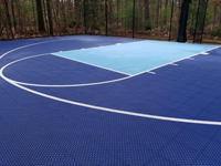 Close view of part of the surface of a blue court in Foxboro.