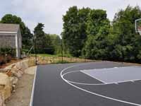 Backyard basketball court in the Cape Cod village of Marstons Mills, in Barnstable, MA, nestled in an empty spot nestled along an existing stone wall.