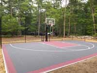 View of most of home basketball court angled from left front, featuring tiles of subdued charcoal and rust colors, installed in Middleboro MA.
